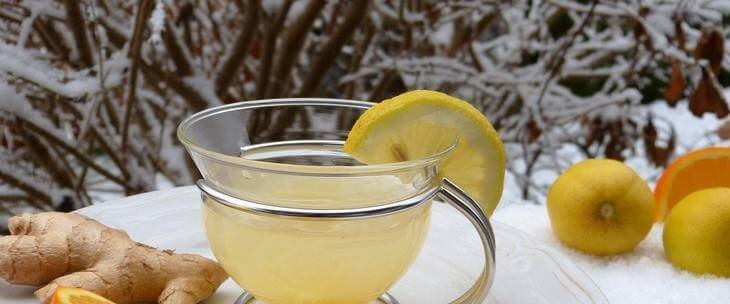 Šolja čaja sa limunom na terasi i sneg napolju