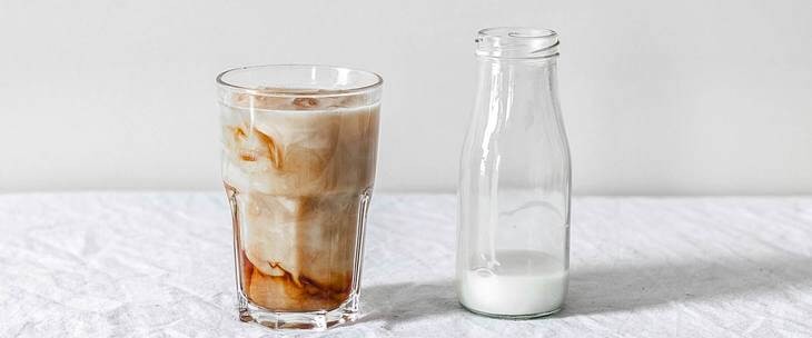 Instant kafa u čaši pored bokala sa mlekom