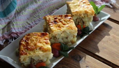 Musaka isečena na kocke i servirana u pravougaonom plitkom tanjiru.